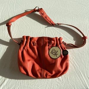 The Sak cinched papaya colored pebble leather shoulder bag